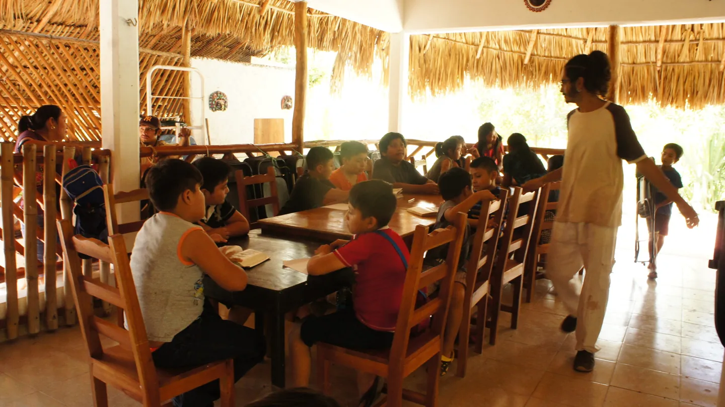 Personas reunidas alrededor de una mesa en un espacio común.