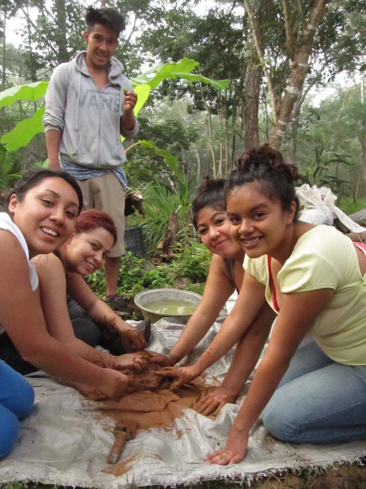 Participantes preparando materiales juntos en una actividad al aire libre.